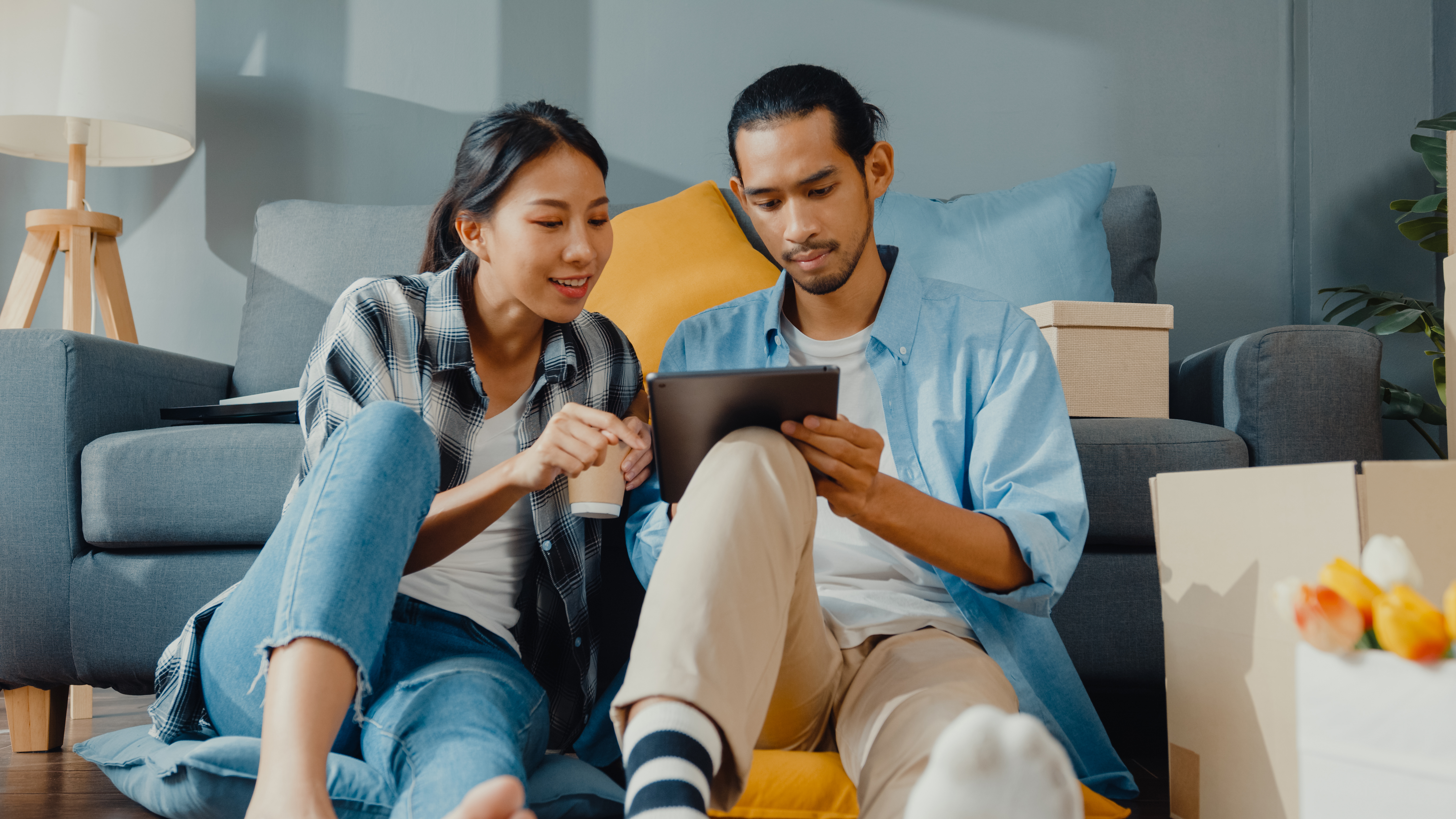 Young couple using tablet in living room
